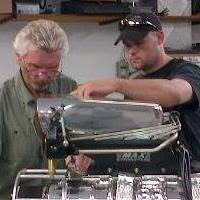 Kirk working with another mechanic on a polished engine