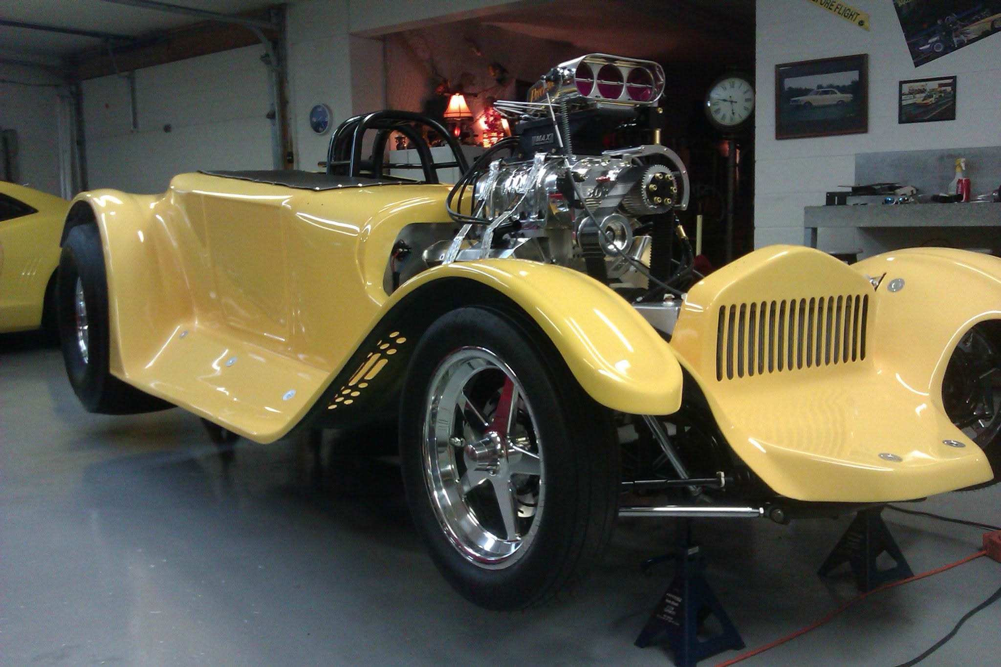 Yellow custom hot rod with exposed supercharged engine